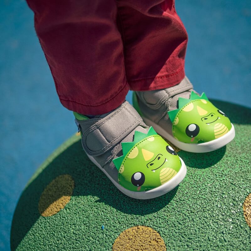 Child in red pants wearing Dragon shoes